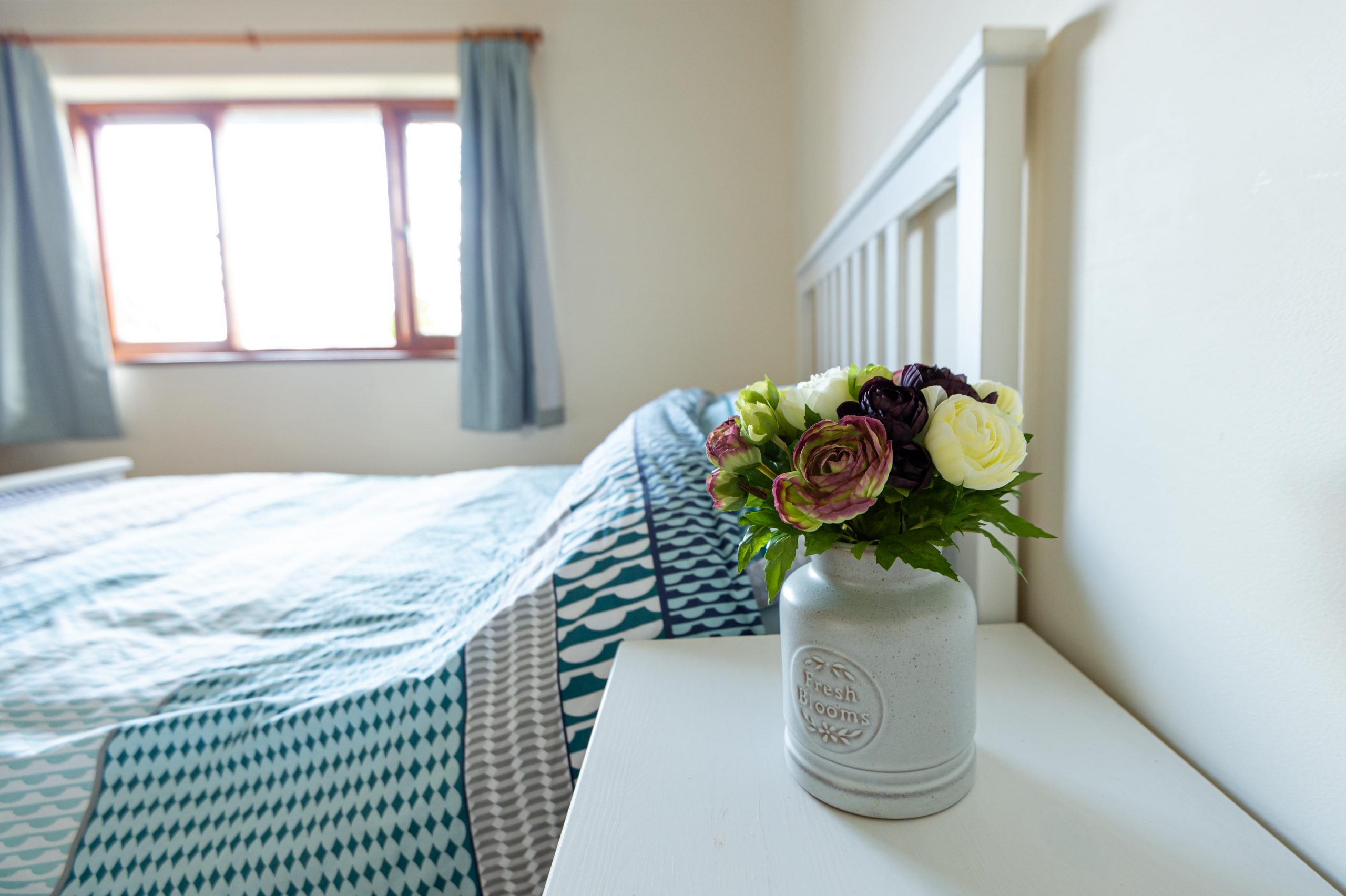 Flowers in front of double bed